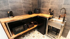A compact kitchen with a built-in dishwasher, a sink, and a coffee maker. - Craven Suite (Scarborough)