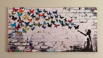 A wall with a graffiti-style painting of a person reaching out to butterflies.