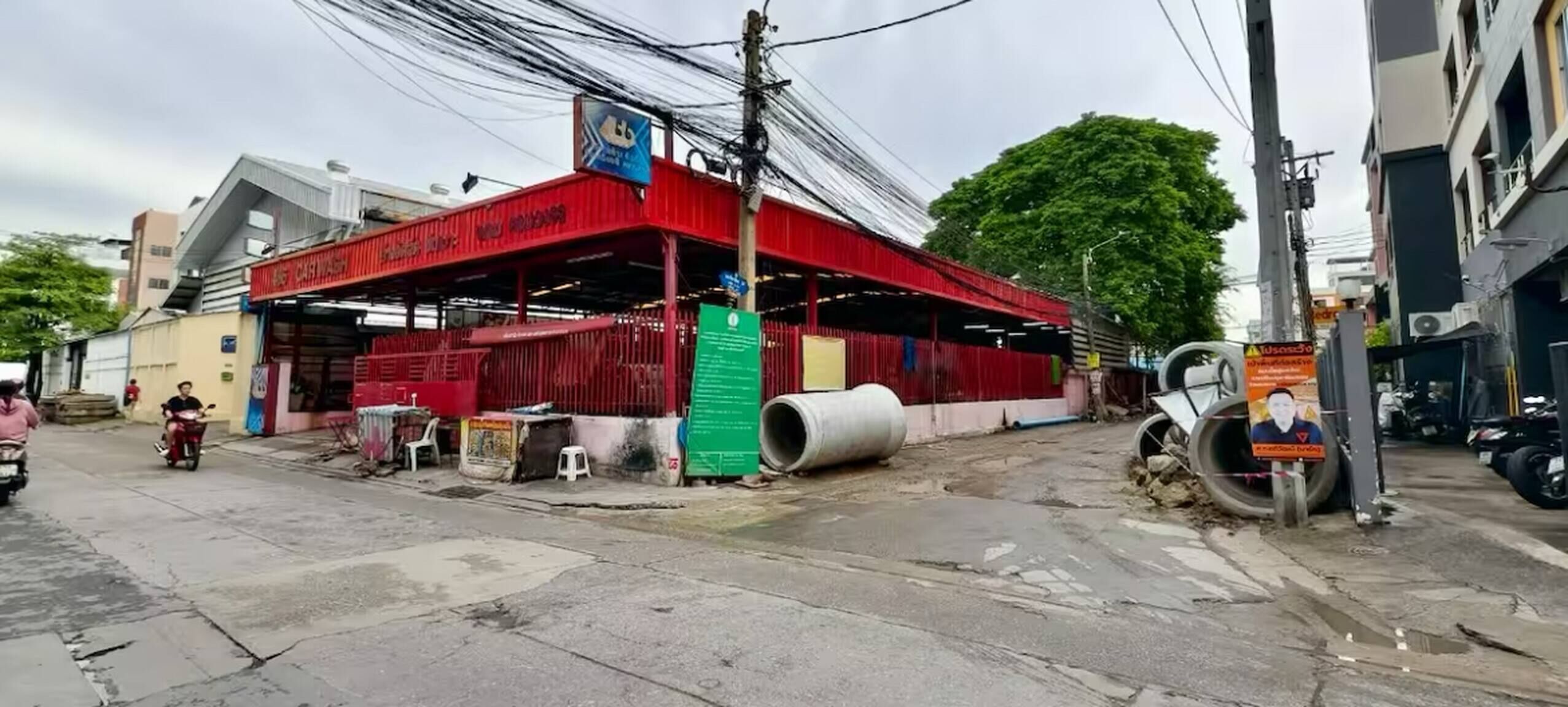 Un bâtiment rouge avec une enseigne sur laquelle on peut lire « LAVAGE AUTO ».