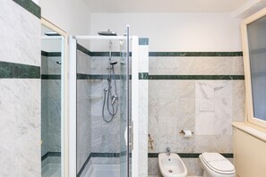 A bathroom with a glass-enclosed shower, a bidet, and a toilet. - San Trifone RiR Collection (Rome)