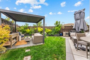 A backyard patio with a covered seating area, outdoor furniture, and a grill. - Welcome  - Modern, North Sacramento Tropical Home (Sacramento)