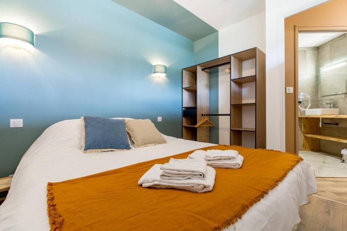 A bedroom with a bed, a wardrobe, and a bathroom visible through an open door.