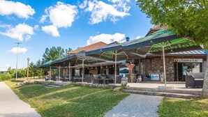A restaurant with outdoor seating, a stone facade, and a sign for 'La Table du Lac.' - Appart Hôtel les Lofts du Grand Lac (Langogne)