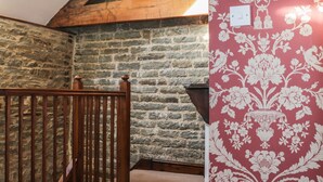 Eine Steinsäule, eine Holztreppe und eine Wand mit Musterpapier.