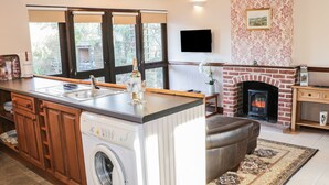 Eine Küche mit integriertem Waschmaschine, Kamin und großem Fenster.