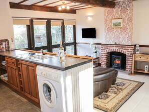 A kitchen with a built-in washer, a fireplace, and a large window. - The Granary (Bucknell)