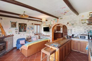 A cozy kitchen with a wooden bar, a sofa, and a fireplace. - Apartment between Pompeii, Sorrento & Positano with Balcony and Wi-Fi (Arola-Preazzano)