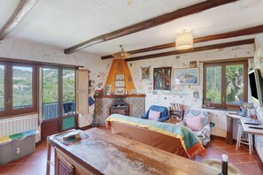 A rustic room with a wooden table, a sofa, a fireplace, and large windows. - Apartment between Pompeii, Sorrento & Positano with Balcony and Wi-Fi (Arola-Preazzano)