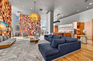 Ein modernes Wohnzimmer mit einer Eckcouch, einem Couchtisch und einem gemusterten Teppich.