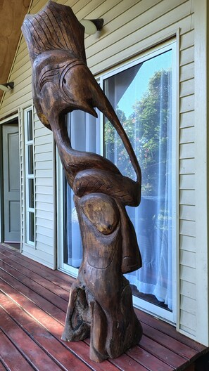 A wooden sculpture on a porch.