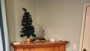 Ein Eckzimmer mit Kamin, einem kleinen Weihnachtsbaum und einer Tür.