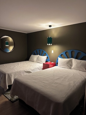 A room with two beds, a round mirror, a red box, and a hanging light fixture. - Berkshire Lake Lodge (Lee)