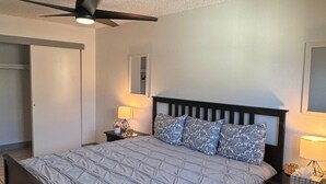 A bedroom with a bed, a ceiling fan, a nightstand, a lamp, and a dresser. - 2Bed1Bath Mostaccioli KingQueenBeds CentralPhoenix (Phoenix)