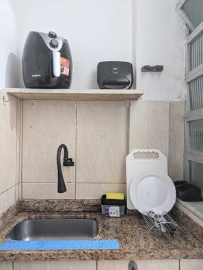 A kitchen with a built-in sink, a coffee maker, a toaster, and a dish rack. - Copanema Apartment (Rio de Janeiro)