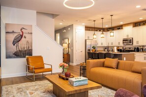 A modern living room with a sofa, a coffee table, and a painting on the wall. - Stupendous Disney Vacation Home W Private Pool (Kissimmee)