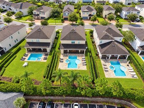 A residential area with multiple houses, a swimming pool, and a parking lot. - Stupendous Disney Vacation Home W Private Pool (Kissimmee)