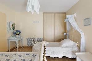Une chambre à coucher comprenant un lit, un bureau, une chaise, une armoire et une table de chevet.