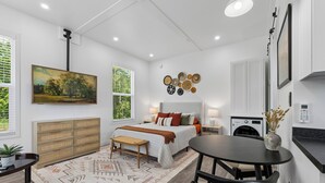 Een moderne slaapkamer met een bed, nachtkastje en een groot raam.
