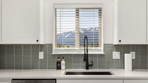 A kitchen with a window, a sink, and a dishwasher.
