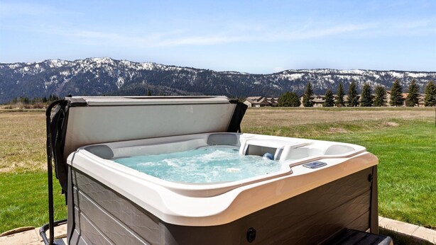 A hot tub in an outdoor setting with a mountainous backdrop.