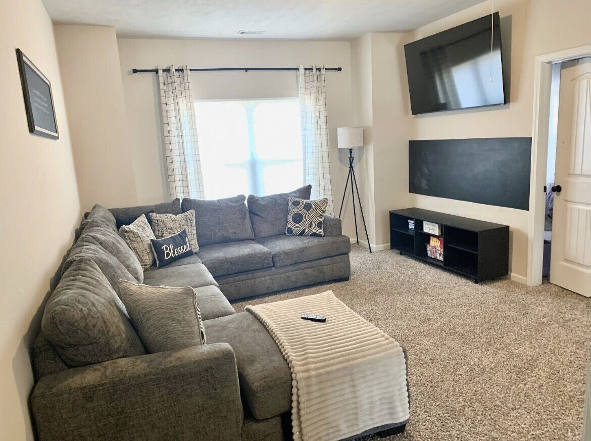 A living room with a sofa, a coffee table, a TV, and a lamp.