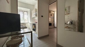 Une cuisine moderne dotée d’un four encastré et d’un coin repas avec une table en verre.