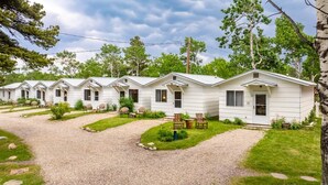 A row of white mobile homes with gravel paths and outdoor seating. - Jacobson's Cottages Cabin # 5 (East Glacier Park)