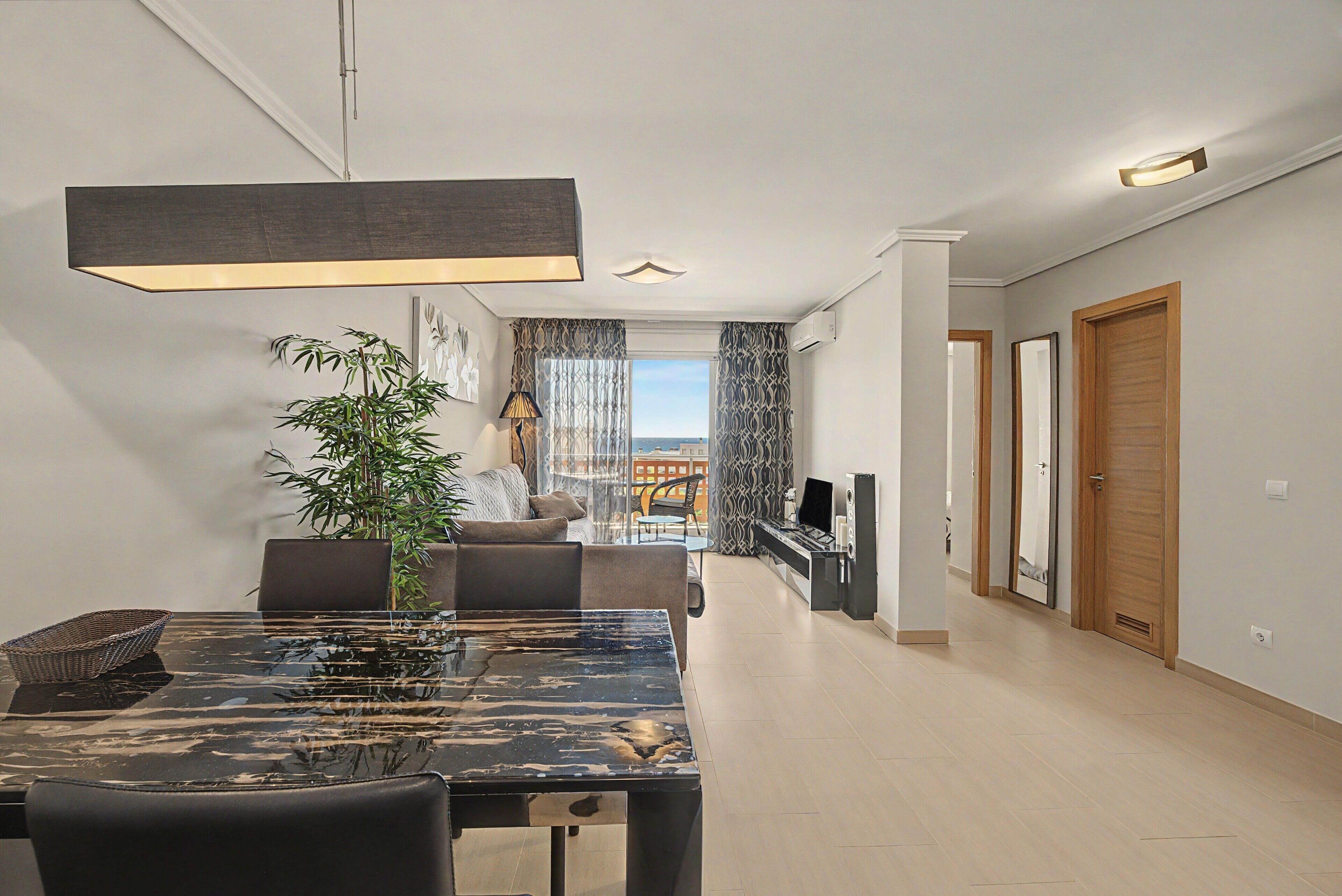 Un salon moderne avec un coin repas, une grande fenêtre et une vue sur la ville.