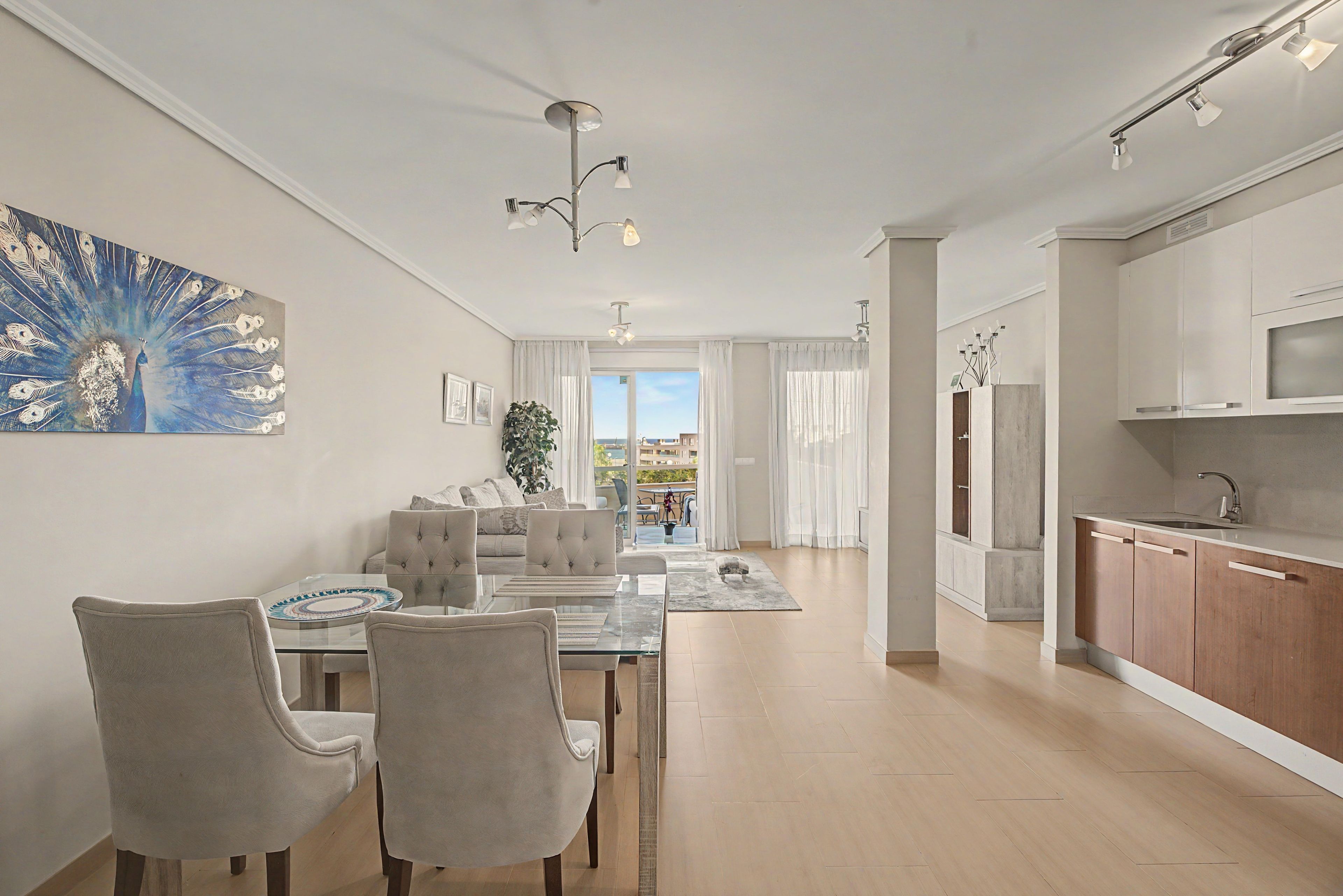 A modern apartment with a dining area, living room, and kitchen.