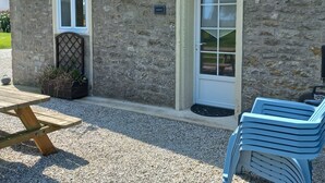 A stone building with a door, a window, and a sign that reads 'Barton.' - Gite Barton 6 persons 500m from Utah Beach (Sainte-Marie-du-Mont)