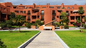 A building with a modern architectural style, featuring a central courtyard with a pathway leading to a seating area.