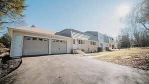 Un immobile residenziale con garage, vialetto e giardino.