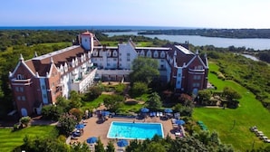A large, historic building with a swimming pool and outdoor seating. - Brand Newly Renovated Resort Style One Bedroom Luxury Suite Simplex (Montauk)