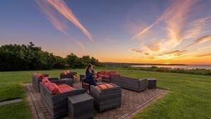 A patio with wicker furniture and a view of the sunset. - Brand Newly Renovated Resort Style One Bedroom Luxury Suite Simplex (Montauk)