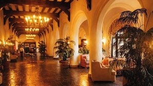 A spacious lobby with a vaulted ceiling, stone flooring, and multiple seating areas with potted plants. - Brand Newly Renovated Resort Style One Bedroom Luxury Suite Simplex (Montauk)