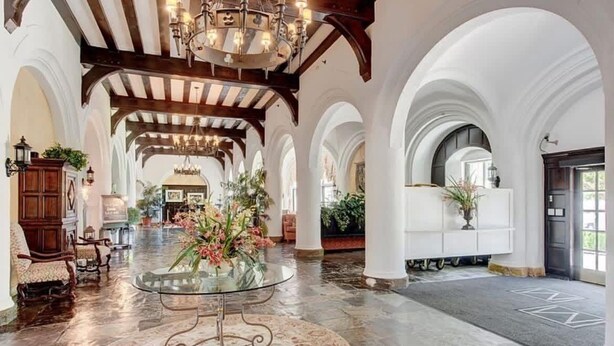 A spacious lobby with high ceilings, arched columns, a grand chandelier, and a central glass table with floral arrangements. - Brand Newly Renovated Resort Style One Bedroom Luxury Suite Simplex (Montauk)