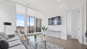 Una sala de estar moderna con sofá, mesa de centro y un amplio ventanal con vistas.