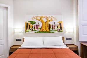 A hotel room with a large bed, two bedside tables, a wall-mounted painting of a tree and figures, and two wall-mounted lamps. - Satriano Essence of Chiaia Flat (Naples)