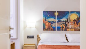 A bedroom with a bed, a nightstand, a wall-mounted light, and a painting of a night scene. - Satriano Style Flat - Double apartment (Naples)