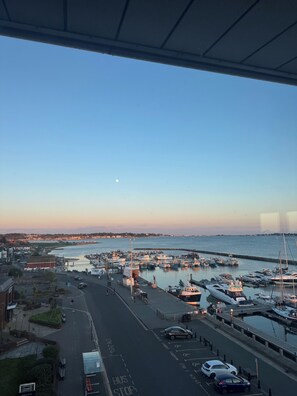 A marina with boats docked, a road with a bus stop, and buildings in the background. - The Lookout-2BR Apartment on Poole Quay Waterfront with Free Parking (Poole)