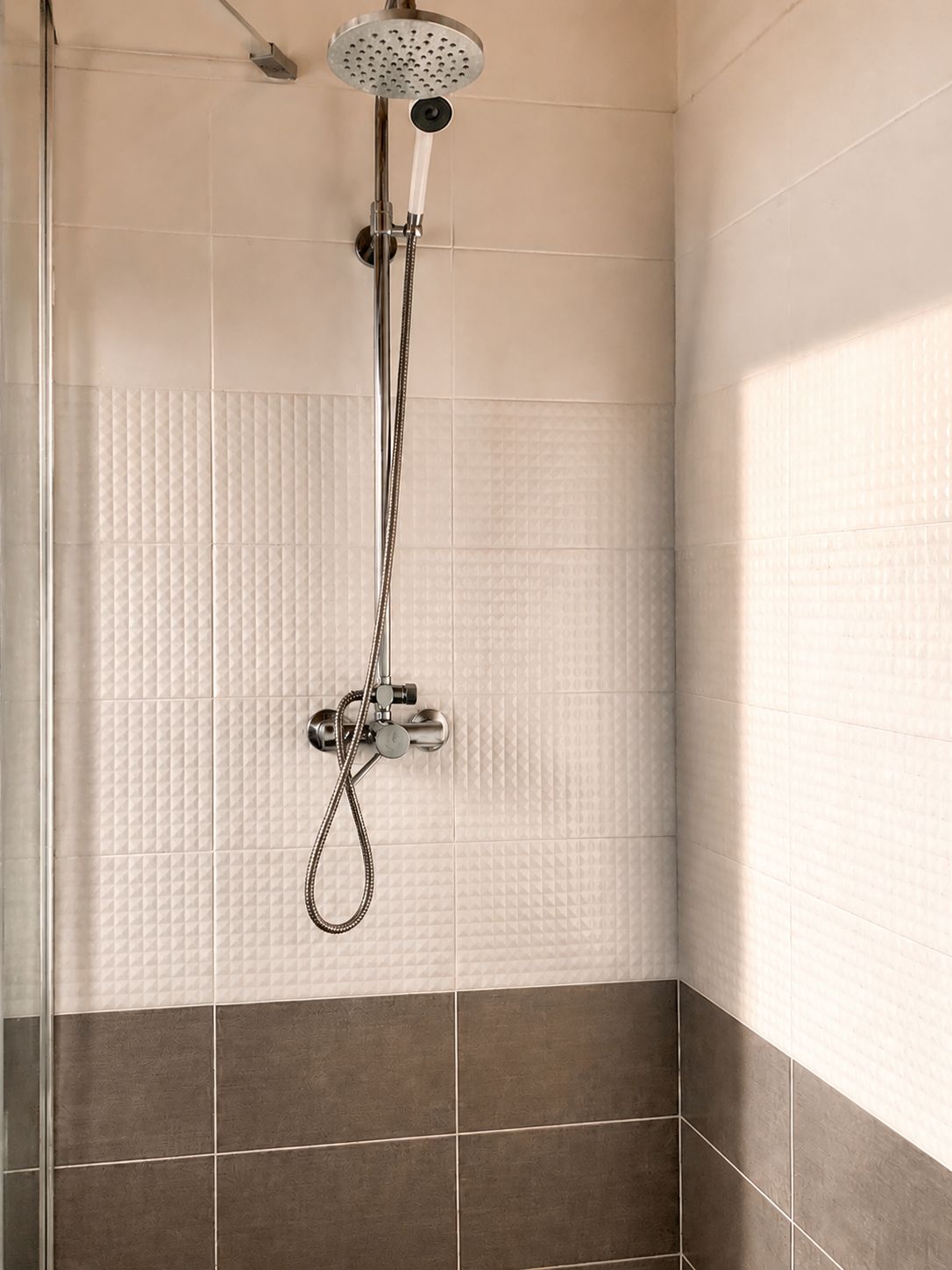 Ducha con cabezal de ducha de mano y llave de control de pared.