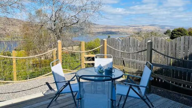 Um terraço com mesa e cadeiras, de frente para uma vista panorâmica.
