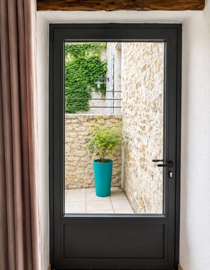 A black door with a window, a stone wall, and a potted plant. - Châteaunette · Mezzanine and Pool   (Saint Montan)