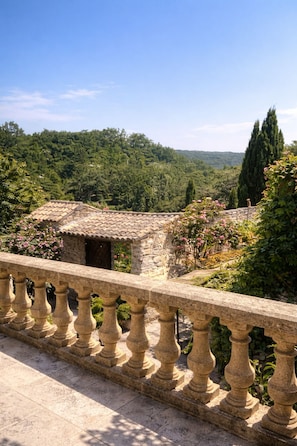 A stone balustrade overlooking a lush garden with a stone building in the background. - Le Mas d'Eylieux - Châteaunette - Haven of peace with swimming pool - South Ardèche (Saint Montan)