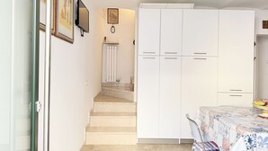 A bedroom with a bed, a wardrobe, a radiator, and a television on the wall. - P092 – Porto Recanati, three-room apartment  (Porto Recanati)