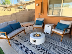 An outdoor patio with a fire pit, two sofas with blue cushions, and a small table. - Pool + Hot Tub Oasis, Family Retreat, Sleeps 7 (Chandler)