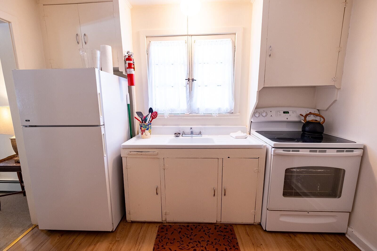 A compact kitchen with a refrigerator, stove, and sink.