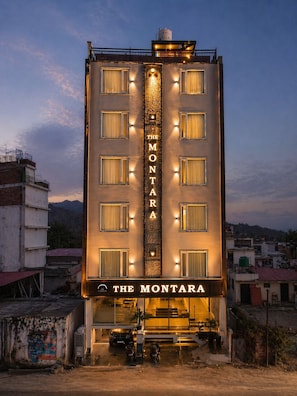 Un hotel llamado 'The Montara' con un letrero vertical, varias ventanas y una entrada visible.