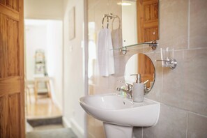 A bathroom with a white sink, a glass shower enclosure, and a wooden door. - Central Urban Retreat Oasis | Free Parking | 13PPL (Sheffield)