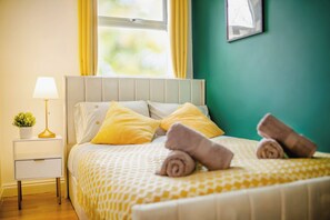 A neatly made bed with rolled towels, a bedside lamp, and a small plant on a nightstand. - Central Urban Retreat Oasis | Free Parking | 13PPL (Sheffield)